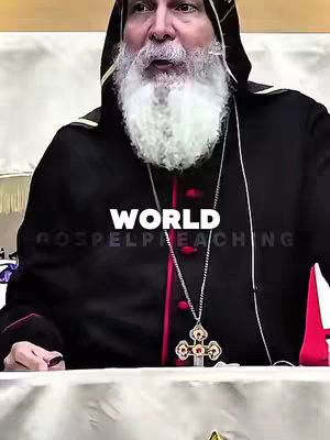 The image features a man with white hair and a full beard dressed in black religious garb and a cross necklace. The text 'WORLD' is overlaid in white letters. The background is a blurred interior setting.