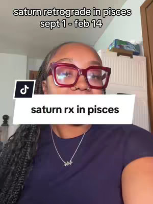 A cover image featuring a Black woman with long braids and red-framed glasses. The image is a selfie-style shot, with the woman's face filling most of the frame. Over her, a white rectangular banner with the text 'saturn rx in pisces' is partially obscuring her.