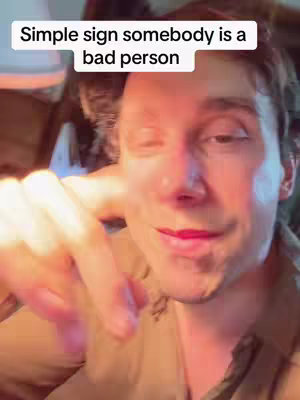 A close-up shot of a man's face with a text overlay. The man is looking towards the camera with a slight smile. The background is blurred and suggests an indoor setting with warm lighting. The focus is on the subject's face and expression.