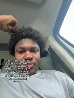 The cover image features a close-up shot of a young Black man with curly hair, wearing a gray shirt. He is positioned slightly off-center, with part of his head out of frame. The background is a mix of light gray and white, possibly the interior of a vehicle. Overlay text is visible on the left side of the image.