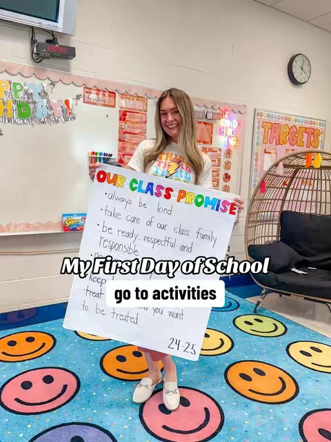 A woman stands in a classroom, holding a poster titled "OUR CLASS PROMISE". The poster lists promises like "always be kind". The woman smiles, and the background includes classroom decor and a clock.