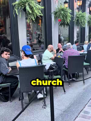An outdoor scene at a restaurant with several people seated at tables. The foreground includes a person with dark hair and a black top. A yellow rectangle with the word "church" is in the middle of the image.