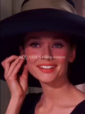 The cover image shows a classic black and white photo of Audrey Hepburn smiling while tilting her head, wearing a large black hat, and lightly touching her ear. The image uses the iconic Audrey Hepburn, featuring large hat and a close-up shot emphasizing on elegance. Text overlayed to the image mentions "AQUARIUS rising women".