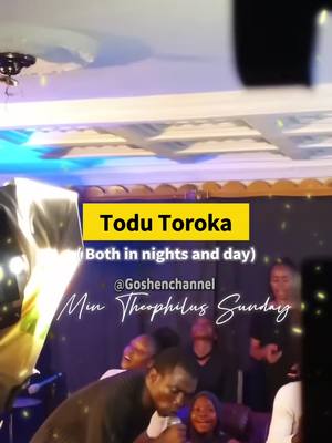 The cover image shows a live performance setting. In the foreground, a man with a microphone is singing, with several other people in the background, some of whom are also singing or watching. There's a yellow box with white text at the top that reads 'Todu Toroka' and below that, '(Both in nights and day)'. The backdrop is dark, with some lights reflecting on it, giving it a live-event, performance aesthetic.