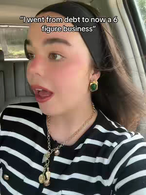 A selfie with a woman in a car, her face is close up with a slight angle view. She has her mouth open and seems to be speaking. The background is her car with a dark tone.