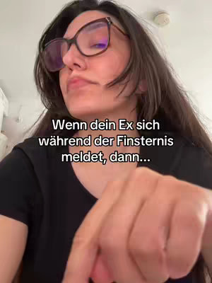 A woman with long dark hair and glasses is in the foreground with a concerned expression. Text is overlaid.
