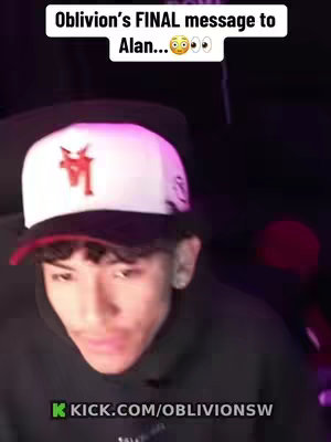 A young man with short hair is centered in the frame, wearing a backwards white and black cap and a black hoodie. The background is dark, with hints of red and other colors. Text overlayed on the top of the image states "Oblivion's FINAL message to Alan..." with surprised  and eye emojis. At the bottom, website text is visible.