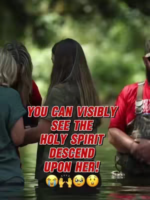 Image shows multiple people standing in water, with text overlayed in red and white, and some emojis in the center bottom. The woman in the middle of the shot has her back to the camera and is at the center, surrounded by two or three persons from the left and right. The water reflects the surrounding green trees.