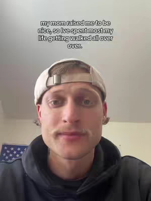The cover image showcases a man in a close-up shot. Above him is text that reads, "my mom raised me to be nice, so I've spent most my life getting walked all over." The man is wearing a baseball cap and a hoodie. The background is a plain wall with a hint of an American flag on the left side.