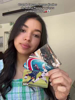 A woman with dark hair holds up three Pixpay cards, smiling at the camera. The background is blurred, potentially in an office setting. The woman is wearing a green and white patterned top. Overlaying the image at the top is a text message indicating that they are launching new card designs, and the purpose is for the user to change theirs, followed by a soccer ball emoji.