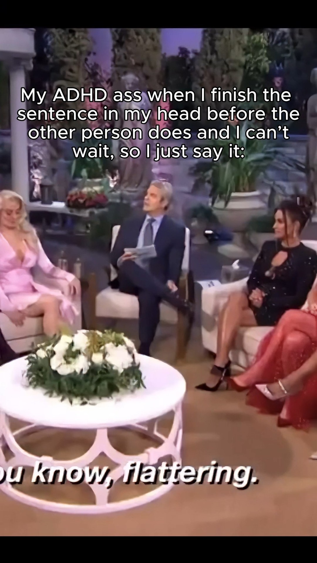 The cover image shows a scene from a talk show or interview setting. The background incorporates soft lighting and a muted color palette. In the foreground, there's a white, floral arrangement atop a round table.  Three women are seated, with the center figure wearing a dark suit, holding a paper. On the women's faces, it gives off a thoughtful or serious expression. The image is clean with a focus on the interview-like setting.