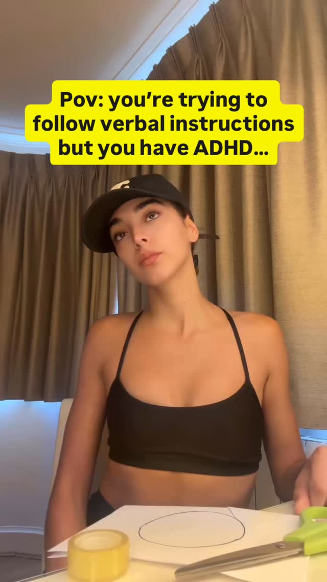 A young woman wearing a black top and a baseball cap is the focal point, slightly angled towards the viewer. Behind her is a window with curtains. Overlaid is a yellow rectangular text box containing the words: "Pov: you're trying to follow verbal instructions but you have ADHD…"