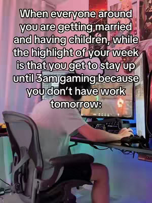 A person sitting at a desk in front of a computer monitor with text overlaid on the image. The person is facing away from the viewer, in a dimly lit room.