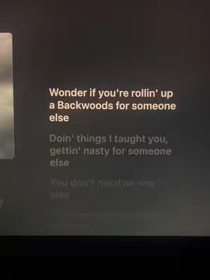 The cover image is a low-light screenshot of a screen displaying song lyrics in white font on a dark background. The layout appears to be a simple arrangement of text.
