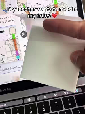 A person's hand holds a blank sticky note over a laptop screen displaying anatomy diagrams. The laptop keyboard and screen are visible with diagrams of the spinal column and vertebrae. Text is overlaid above.