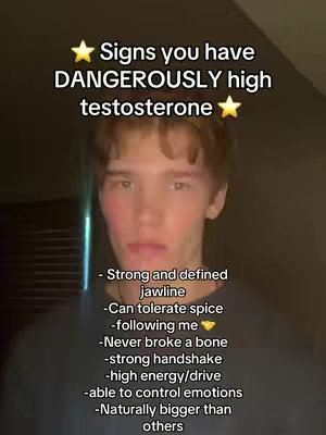 The image shows a young man with brown hair, centered in the frame. Above him, text overlaid in a bold, sans-serif font reads, \"Signs you have DANGEROUSLY high testosterone\". Below him, a list of signs, written in a similar font, includes: strong jawline, tolerance for spice, following the creator (with a yellow heart emoji), never breaking a bone, strong handshake, high energy/drive, control of emotions, and being naturally bigger than others. The background is a simple, dark gradient, with the man's face being well-lit.