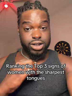 A man with dark skin and a beard stands in front of a camera. He has a nose ring and is wearing a black tank top. Text overlays the bottom of the image.
