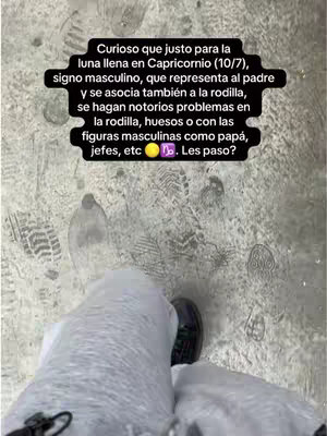 The image shows a person's legs walking across what appears to be a snowy or gritty surface, possibly a sidewalk or pavement. The person is wearing pants and dark shoes. Overlayed on the scene is a dark text box with a white border, featuring text that seems to explain astrological concepts, including references to the full moon in Capricorn, along with associated themes such as the father figure, problems, and solutions. The text is written in Spanish.