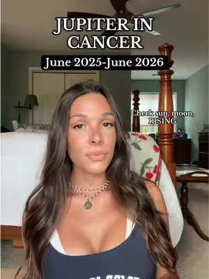 A young woman with long brown hair stands in front of a bed in a light-filled room. Text overlays describe "Jupiter in Cancer" with the dates June 2025 - June 2026.