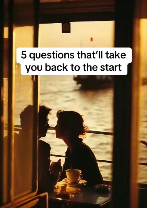 The image shows a warm, romantic scene within a cafe or restaurant setting. The composition is framed through a window or doorway, emphasizing depth. Two figures, silhouetted against a bright backdrop, are close to each other, appearing to be deep in conversation. A table with a cup of coffee adds a detail to the foreground. The overall feel is of intimacy and nostalgia, with a golden-hour lighting.