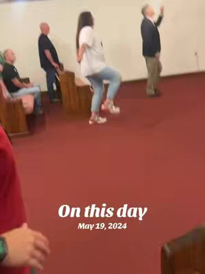 A video cover shows a scene inside what appears to be a church or event hall. A woman is dancing, viewed from the back, while several people are standing on the periphery, and a couple of people sit on pews. The text overlayed in the image says, “On this day, May 19, 2024.” The backdrop is an off-white wall, with reddish-brown carpet on the floor.