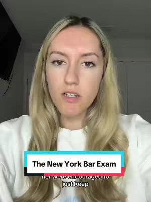 A woman with long blonde hair, wearing a white sweater, is centered in the frame, looking directly at the camera. The background is somewhat out of focus, with a dark area on the top left, possibly a TV, and a white door or cabinet on the right. Text overlays read 'The New York Bar Exam' in a teal and black bar.