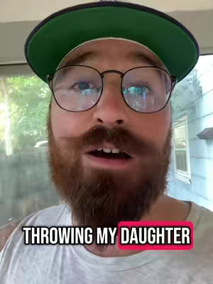A man with a red beard wearing glasses and a green hat is the focus. A text overlay reads: 'THROWING MY DAUGHTER.' The background is blurred, suggesting a focus on the man.