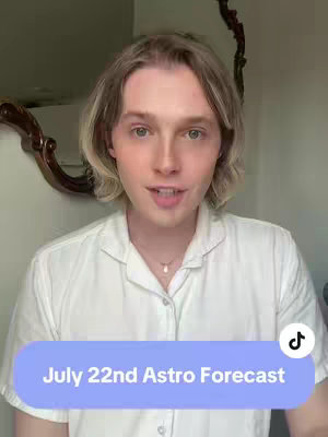 A person with blonde hair and a white shirt is centered in the frame, with a partially visible ornate brown mirror in the background. The person is looking and talking to the camera with a light blue box at the bottom with the text "July 22nd Astro Forecast".