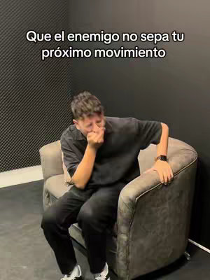 The cover image shows a man sitting on a grey armchair in a room. He is wearing a black t-shirt and black pants and is holding his hand to his mouth as if suppressing a laugh. There is text overlaid on the image.