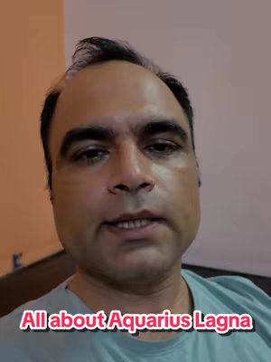 A medium shot of a man's face. He has short, dark hair, a slightly receding hairline, and is wearing a light blue t-shirt. The background is a mix of beige and light brown, and superimposed on the man is a pink and white text overlay that reads, "All about Aquarius Lagna."
