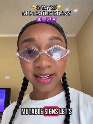 A selfie-style video cover featuring a young woman. She has braided pigtails and is wearing clear-framed, diamond-shaped glasses. Text overlays across the top and the bottom of the screen. The background is a neutral-toned interior space with soft lighting.