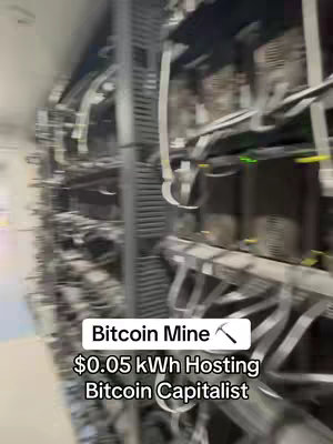 The image shows rows of computer equipment. In the foreground, a text overlay provides details about Bitcoin mining and hosting costs.