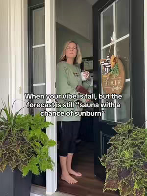 A woman stands barefoot in a doorway, holding a mug and a small item, likely a phone or wallet. Behind her is an interior space, and the setting appears to be a house entrance with a porch. Text overlays at the bottom of the image provides context for the image.