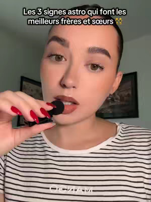 A woman with brown hair and a striped shirt holds a black microphone near her lips. White text on a black bar across the top says: Les 3 signes astro qui font les meilleurs frères et sœurs.