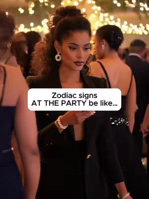 A well-dressed woman at a party is the central focus of the image. She is wearing a black blazer and holding a phone, appearing to be looking at it. Other people are present in the background, creating a party atmosphere with soft, blurred lighting.
