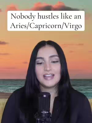 A woman with long black hair is centered in the frame, wearing a black top and speaking into a microphone. Behind her is a backdrop of a sunset over the ocean, with a text overlay at the top that reads, "Nobody hustles like an Aries/Capricorn/Virgo."