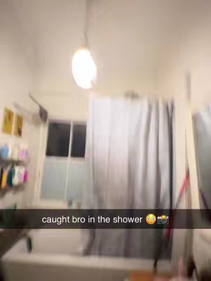 A blurry, point-of-view shot of a shower. A light is hanging above, and a shower curtain is visible on the right. Text overlays at the bottom.