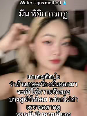 A selfie-style shot featuring a young woman. She has blonde hair with dark roots and a fair complexion, with visible makeup. She is touching her hair with one hand, while the top half of her body is visible with a neutral background. The color scheme seems somewhat muted, dominated by skin tones, with potential for warmer tones from the backdrop.