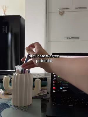 The cover image shows a hand holding colored pens over a cactus-shaped pen holder, with a laptop open in the background, set on a desk. Text overlay on the image: 'but I hate wasted potential.'
