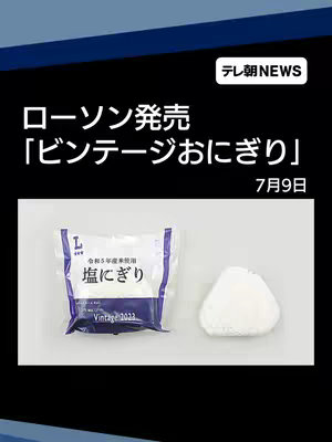 The image shows a Lawson product display in a news-style layout. It features text overlays with the Lawson logo, product information, and date. Below the text, there is a packaged onigiri next to the unpackaged product. The background is a dark blue with lighter blue accents at the top.