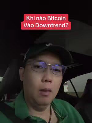 The cover image shows a man in the driver's seat of a car. He's wearing glasses and a green cap. The top of the frame includes a red box containing the text "Khi nào Bitcoin Vào Downtrend?" against a black background.
