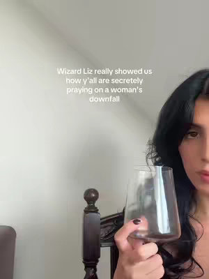 A woman with dark hair is holding a clear glass. Text in white is overlaid on the top-left of the image.
