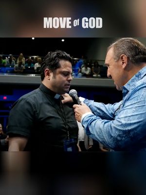 A cover image shows a medium shot of two men inside a building. One man, wearing a black collared shirt and a clerical collar, is the primary focus. Another man, in a light blue patterned shirt, is positioned to the right, holding a microphone in front of the first man; the second man is touching the first man's chest area as well. Overhead superimposed text reads 'MOVE of GOD'. The background appears blurred with people in attendance.