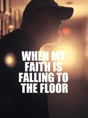 A silhouette of a man in a baseball cap is against a backlit interior. The background is blurred, and a bright light source is to the right, enhancing the silhouette. Text overlayed on the image reads, "WHEN MY FAITH IS FALLING TO THE FLOOR".