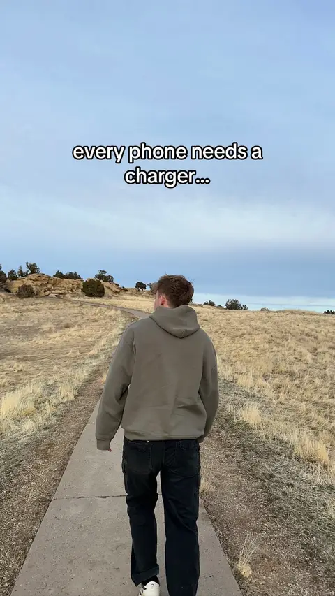 The cover image shows a man walking away from the camera on a path through a grassy field. He is wearing a hoodie and jeans. The sky is overcast, and there are some rocks and trees in the background.