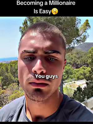 The image is a selfie-style shot featuring a young man from the chest up, posing with a serious expression. The background shows a blurred natural setting with trees and greenery, suggesting an outdoor location. Overlayed text, 'Becoming a Millionaire Is Easy 😮',appears at the top of the image, while the text 'You guys' appears at the bottom. The man wears a grey t-shirt and the lighting seems to be natural, adding to the casual feel of the image.