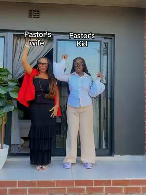 Two women, a mother and a daughter, stand smiling in front of a door and windows. The mother wears a black dress with a red cape, and the daughter wears a blue and white shirt with beige pants. Text overlays read 'Pastor's wife' and 'Pastor's Kid'.