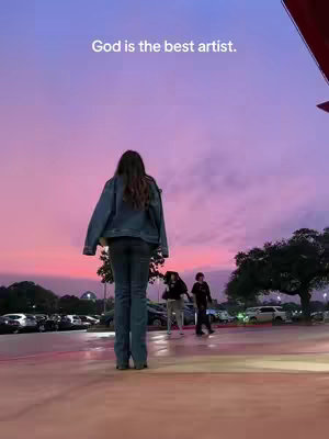 A medium shot of a young woman from the back, standing in front of a vivid sunset with pinks and purples. The sky is the primary element, with the woman and some other people in the mid-ground and background. The woman is wearing jeans and a denim jacket. The image is set in what appears to be a parking lot, with cars and a structure visible in the distance. Text overlays the image.