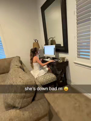 A woman sits at a desk in front of a computer, wearing a white dress, with a distressed emoji, suggesting her reaction to a situation, alongside the caption regarding crypto.