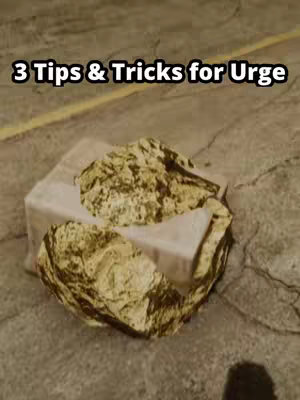An overhead shot shows a rough, stone-like surface filling the lower portion of the frame, where a gold-leafed object resembling a rock sits atop a white, rectangular object. Above this, in the upper half, text appears saying '3 Tips & Tricks for Urge' in a simple, clean sans-serif font. The background has a slightly blurred appearance.